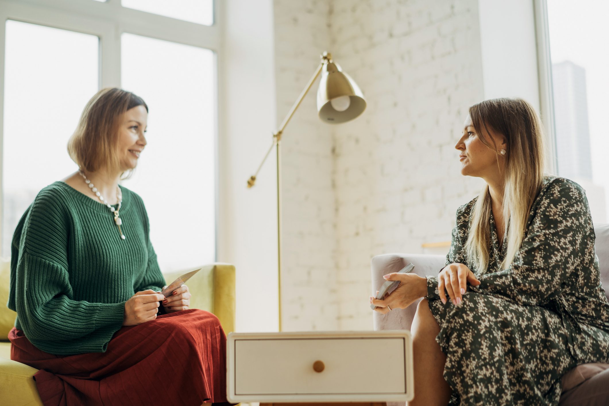 A female psychiatrist smiles as she listens to her female patient attentively