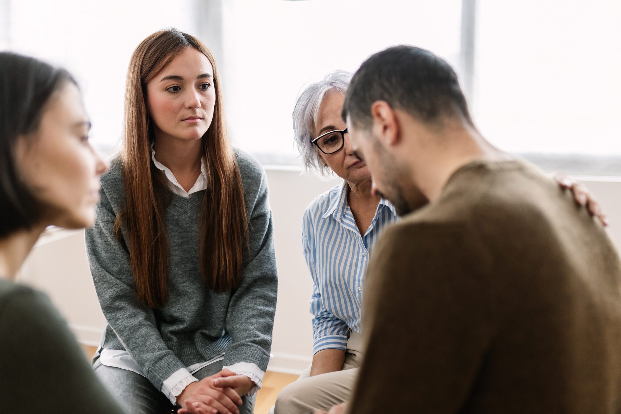 Man is comforted by peers in group therapy