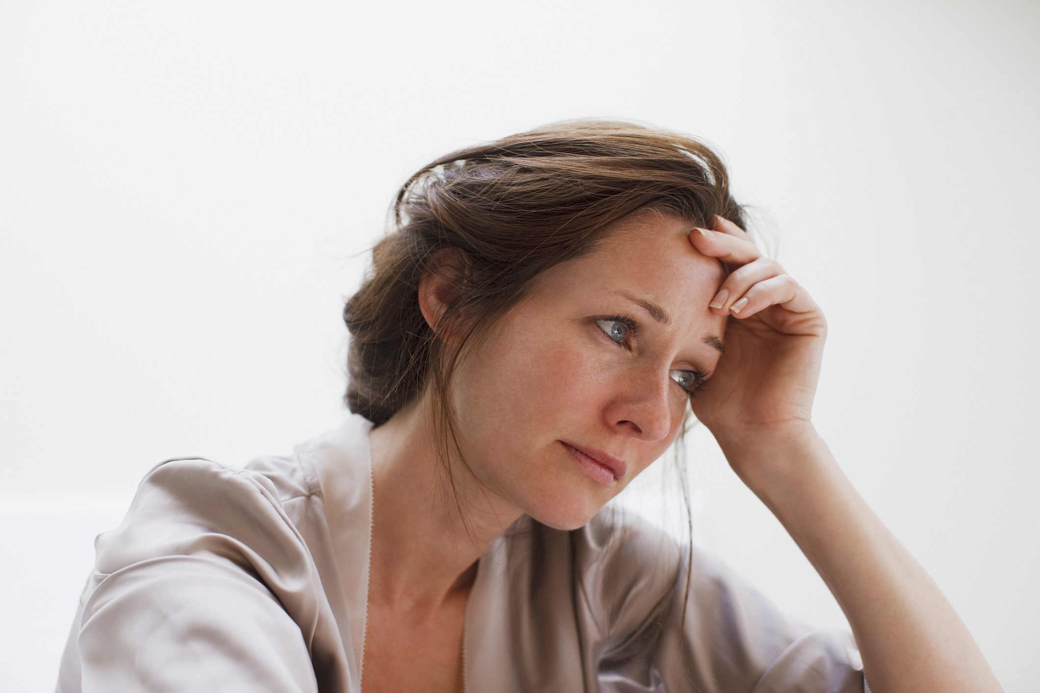Stressed woman holds her hand to her head